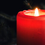 Photograph of an Yule candle and evergreen boughs, by Flickr user Ksenia Yakovleva and entered into the public domain.